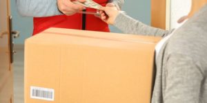 Young woman paying for parcel received from courier Young woman paying for parcel received from courier